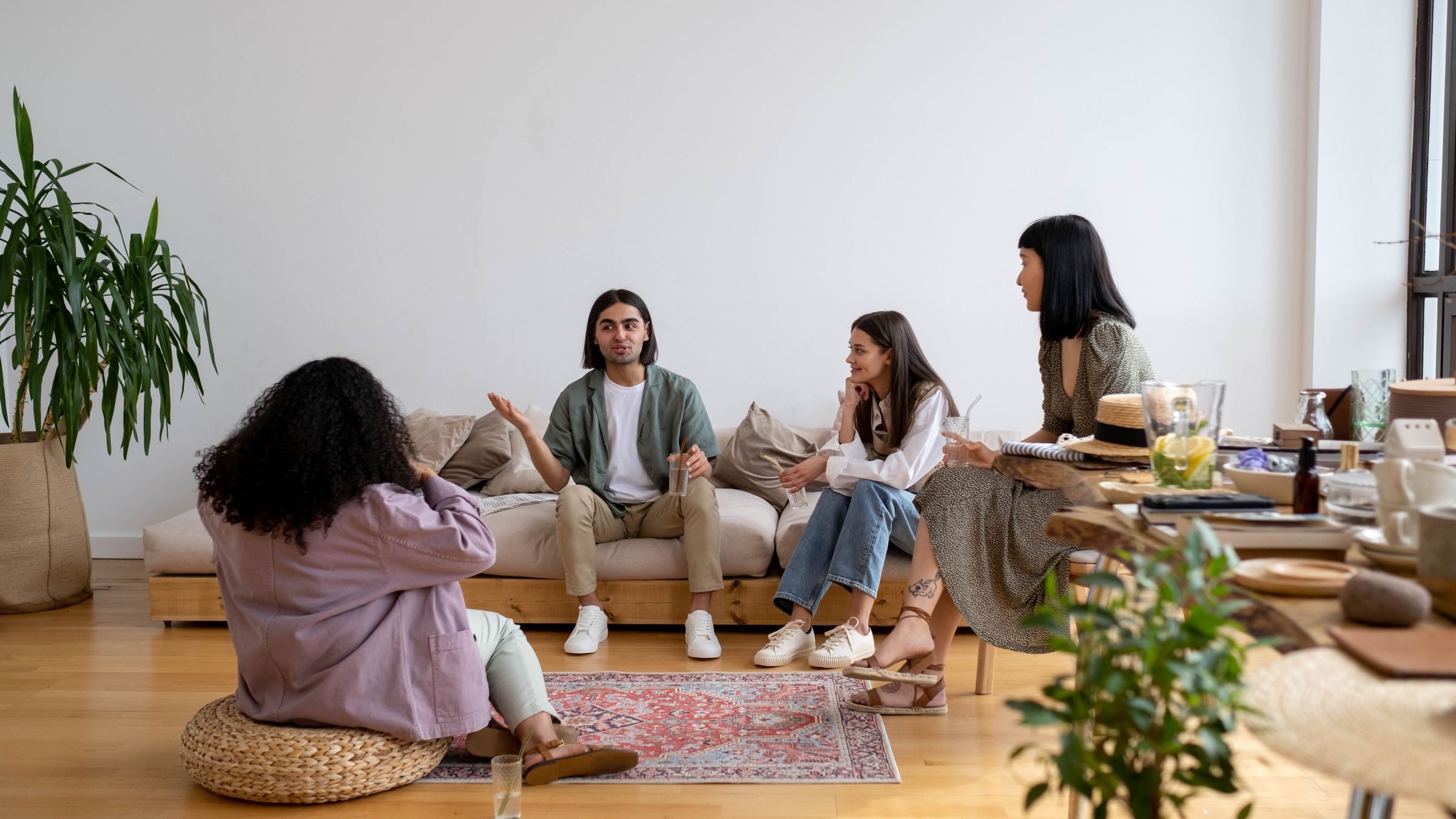 Four adults talking together in a bright living room