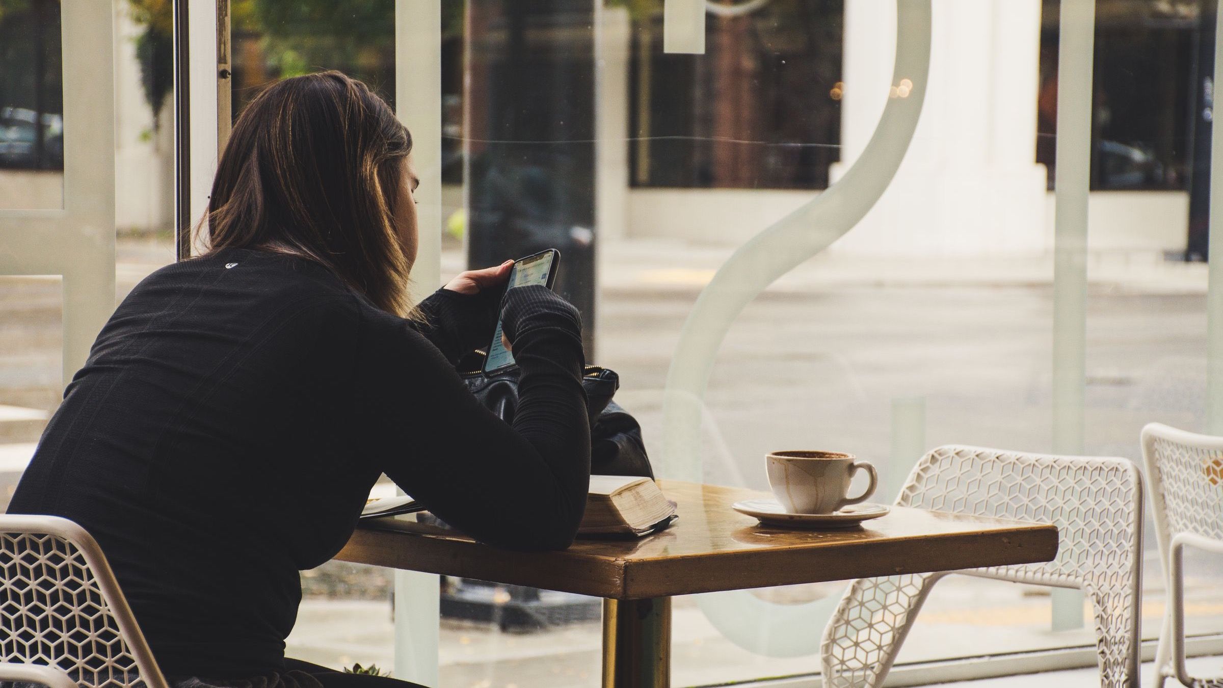 A woman using a smartphone at a coffee shop table