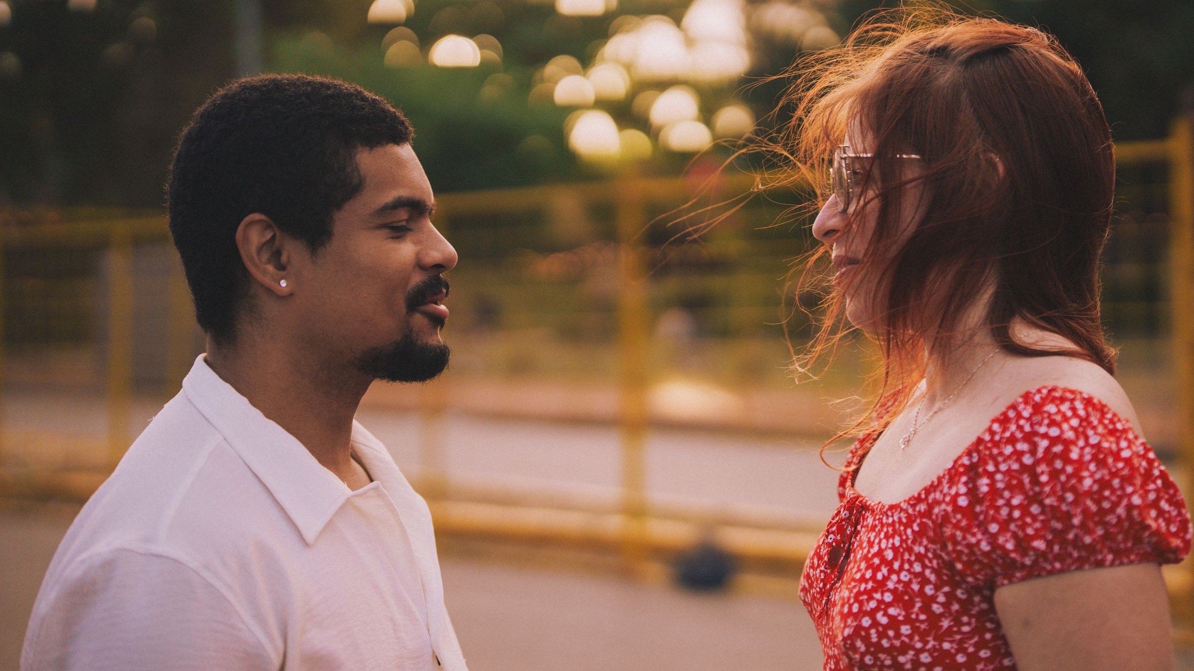 Two adults talking face to face outdoors in warm evening light