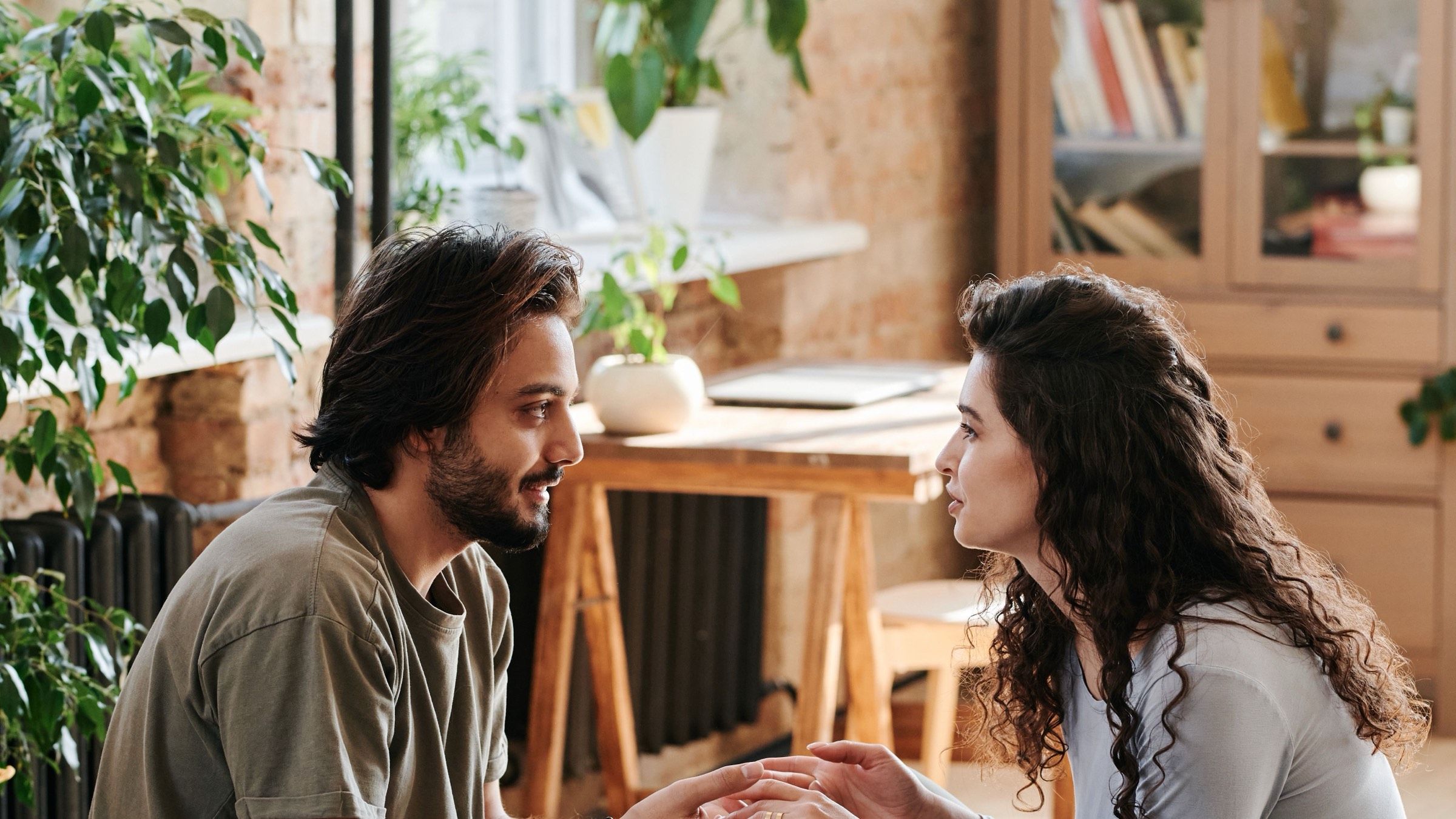 Two adults sitting face to face in a sunlit room